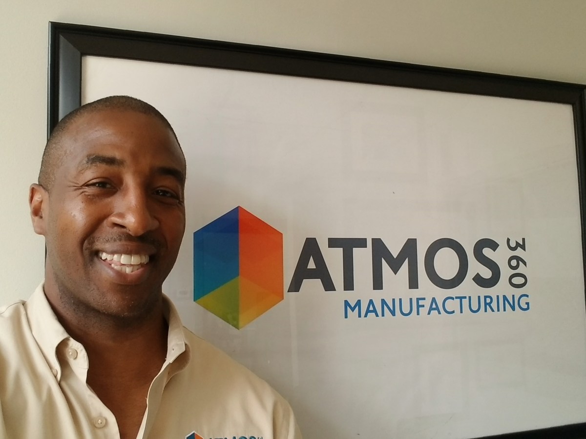 Black Man with company logo in the background, Atmos