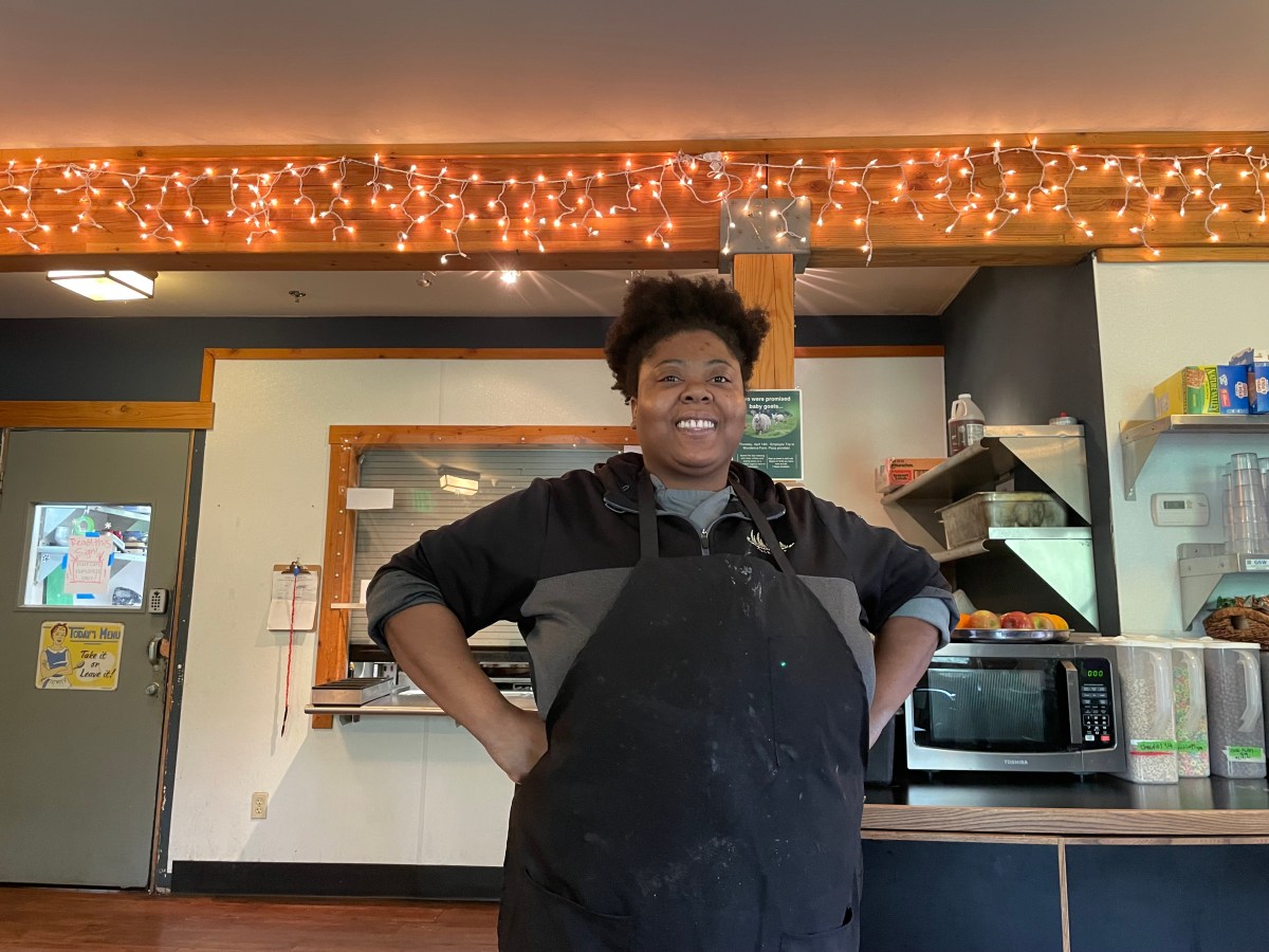 Black woman standing confidently in an apron